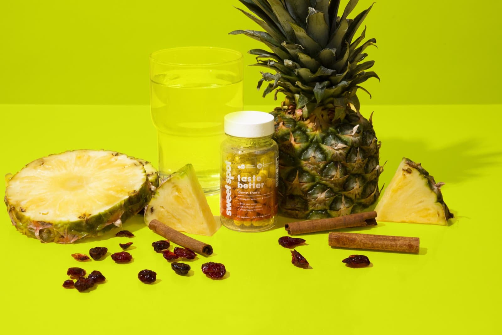 For Her bottle with a whole pineapple, cut pineapple, cranberries, cinnamon, and water on lime