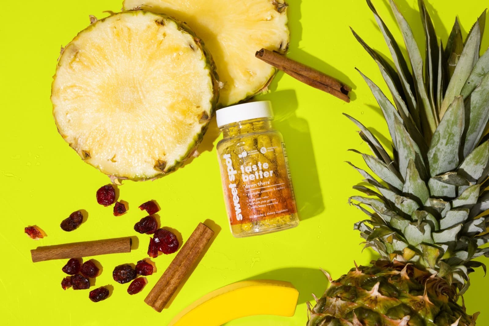 Overhead For Her bottle with pineapple, cranberries, and cinnamon on lime